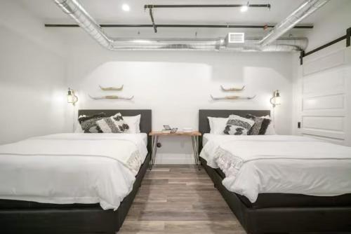 two beds in a room with white walls at Sweet escape luxury urban cowboy rino arts loft - jz vacations rentals in Denver