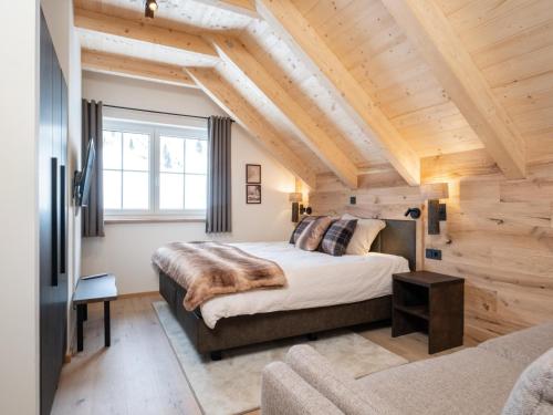 una camera con un grande letto in una stanza con soffitti in legno di Edelweiss Lodge a Donnersbachwald
