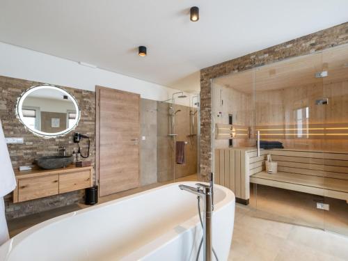 a bathroom with a tub and a sink and a mirror at Edelweiss Lodge in Donnersbachwald