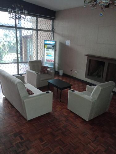 a living room with white furniture and a fireplace at MUNDO HOSTAL in Guatemala