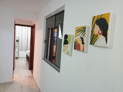 a group of paintings on a wall in a room at Samambaia QI 616 in Brasilia