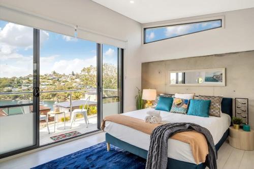 a bedroom with a large bed and a balcony at Picture-Perfect Masterpiece In Mosman in Sydney