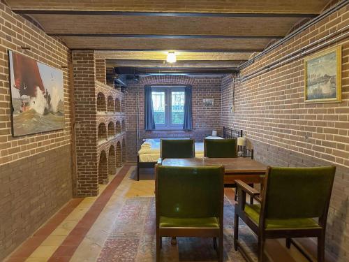 a room with a brick wall and a table and chairs at Groot Weeshuis in Enkhuizen