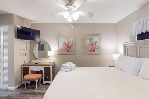 - une chambre avec un lit blanc et un ventilateur de plafond dans l'établissement Polynesian Village - Unit 222, à Panama City Beach