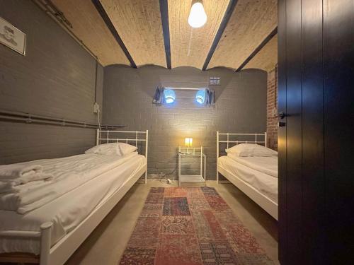 a room with two beds and a window at Groot Weeshuis in Enkhuizen