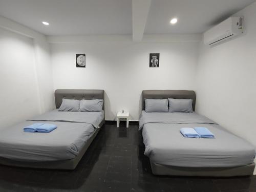 two twin beds in a room with a table at 184 GURNEY DRIVE PENANG in George Town