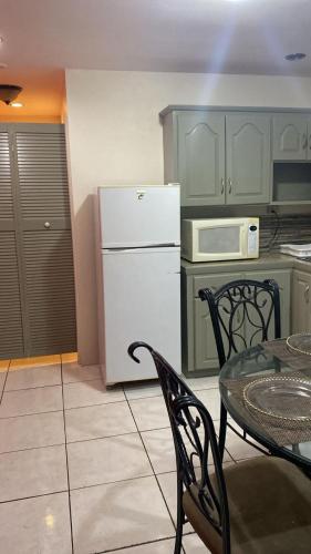 een keuken met een witte koelkast en een tafel en stoelen bij Riverside Apartment in Arouca
