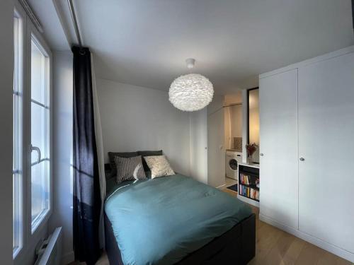 um quarto com uma cama e uma grande janela em Appartement au cœur du Marais em Paris