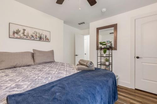 um quarto com uma cama com um cobertor azul e um espelho em Cozy 3br downtown red door house em Jeffersonville