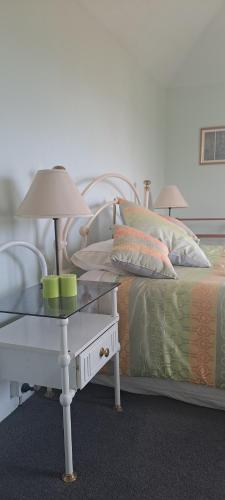 1 dormitorio con 1 cama y 1 mesa con lámpara en Ardross House, en Amberley