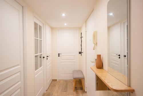 - un couloir avec des portes blanches et un bureau en bois dans l'établissement Palazzio T3 design près des plages et du Palais, à Cannes