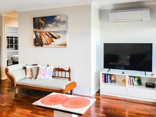 a living room with a couch and a flat screen tv at West End Luxury 4B3B Home w Parking and Home Pod Music System in Brisbane