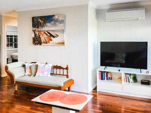 a living room with a couch and a flat screen tv at West End Luxury 4B3B Home w Parking and Home Pod Music System M9 in Brisbane