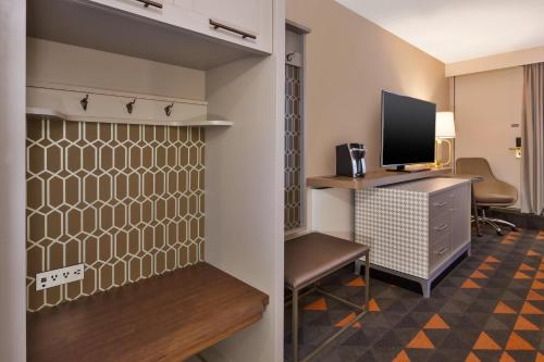 a room with a desk and a tv and a room with a chair at Holiday Inn St Johns by IHG in St. John's