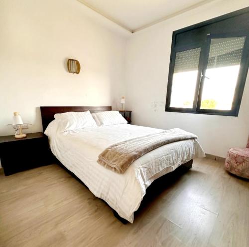 a white bedroom with a large bed and a window at Rest, sea and sun in Agadir