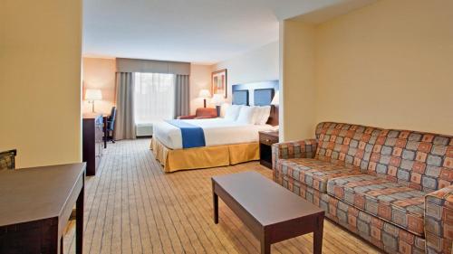 スウィフト・カレントにあるHoliday Inn Express Hotel & Suites Swift Current, an IHG Hotelのベッドとソファ付きのホテルルーム