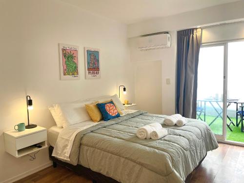 1 dormitorio con 1 cama grande y toallas. en Alfonsina Hostel en Buenos Aires