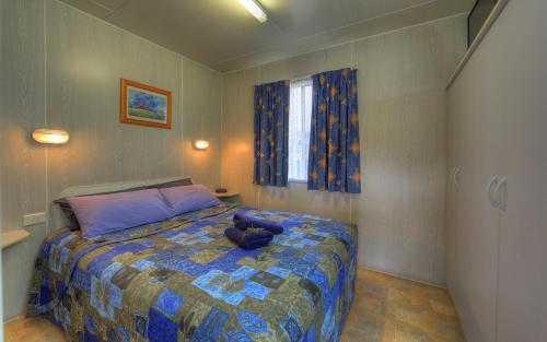 Un dormitorio con una cama con un osito de peluche. en Governors Hill Carapark, en Goulburn