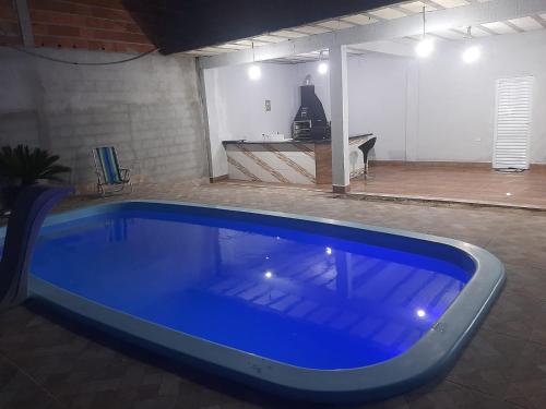 een groot blauw zwembad in een garage bij Recanto caçapava in Caçapava