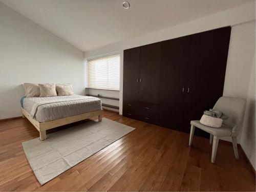 a bedroom with a bed and a chair and a window at La Casa del Agua Puebla in Acatepec