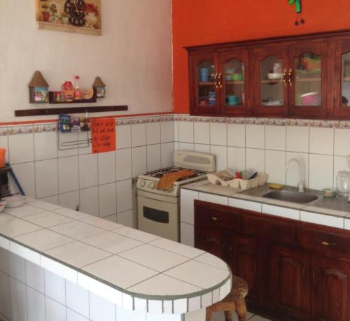 cocina con paredes de azulejos rojos y blancos en Hostal Brisas y Olas, en San Juan del Sur