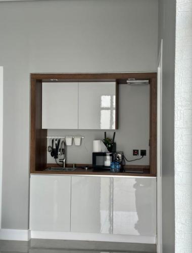 una cocina con armarios blancos y una ventana en REST IN 2, en Unaizah