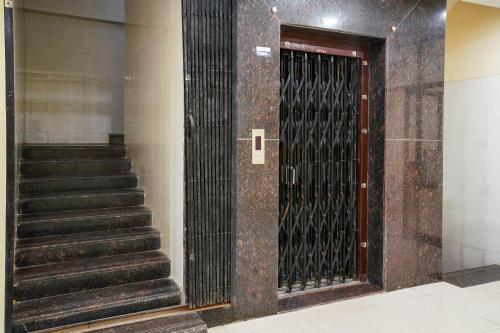 a metal door with stairs in a building at 69076 OYO Hotel Sweekar in Shamshabad