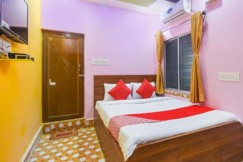 sypialnia z łóżkiem z czerwonymi poduszkami i oknem w obiekcie Flagship Black Diamond Hotel and Restaurant Barasat w mieście Bārāsat