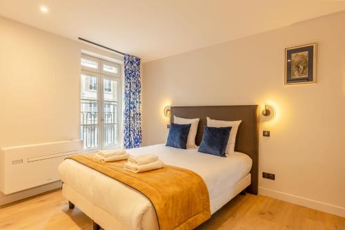 une chambre avec un grand lit avec des oreillers bleus dans l'établissement L'Escale du Vieux Port - 1st floor - Airco, à Honfleur