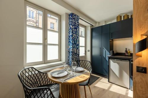 une petite cuisine avec une table et des chaises dans une pièce dans l'établissement L'Escale du Vieux Port - Studio Ground Floor 2P - Airco, à Honfleur