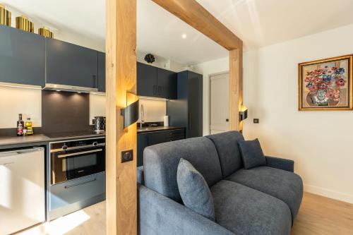 un salon avec un canapé et une cuisine dans l'établissement L'Escale du Vieux Port - Studio Ground Floor 2P - Airco, à Honfleur