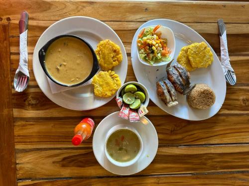 a table with two plates of food and a bowl of soup at Awa De Mar Hotel Tolu in Tolú