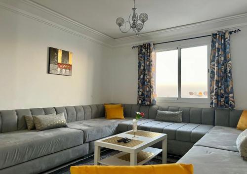Bord de Mer: Appartement à 500m de la Plage & Surf في أغادير: غرفة معيشة بها أريكة وطاولة