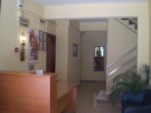 a lobby with a desk and stairs in a building at Hotel Apolafsi in Volos