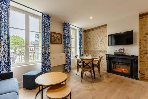 un salon avec une table et une cheminée dans l'établissement L'Escale du Vieux Port 4P - Closed Garage - Sauna - Air Conditioning, à Honfleur