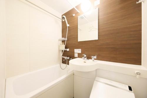 a bathroom with a toilet and a sink at Hotel Shinjukuya in Machida