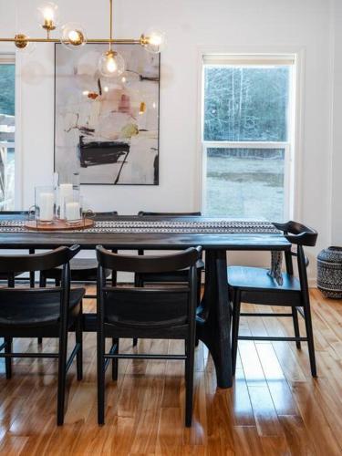 a dining room with a table with chairs and a painting at Woodstock Retreat- Heated Pool/Hot Tub/FirePit in Saugerties