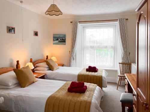 a hotel room with three beds and a window at Atlantic House - 27665 in Port Isaac