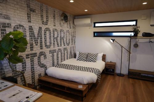 1 dormitorio con cama y pared de ladrillo en RGH ISHIUCHI BASE02 - Vacation STAY 14828, en Hiroshima