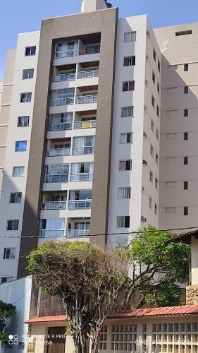 a tall building with a tree in front of it at Vista da Orla de Itapoã - 1002 in Vila Velha