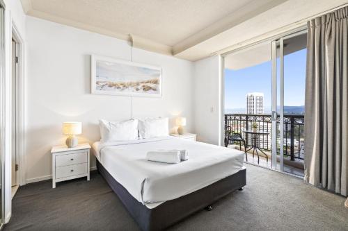 een witte slaapkamer met een bed en een balkon bij KIDS STAY FREE in Hinterland View 2 Bedroom 1 Bathroom Apartment at Chevron Renaissance- Q STAY in Gold Coast