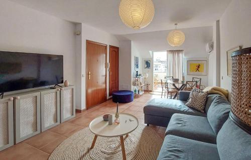 a living room with a blue couch and a tv at Awesome Apartment In Fuengirola in Fuengirola