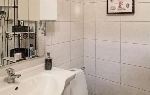 a white bathroom with a sink and a toilet at Stunning Home In Trynisze Moszewo With Wifi in Ciechanowiec