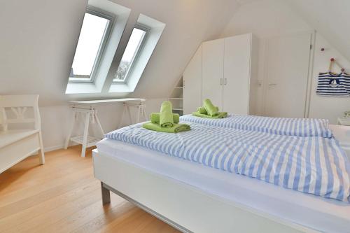 a bedroom with a bed with green chairs on it at Orange Hygge Haus in Langeoog