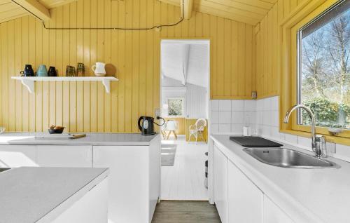 2 Bedroom Beautiful Home In Tisvildeleje في تيزفيلدليدج: مطبخ مع دواليب بيضاء ومغسلة