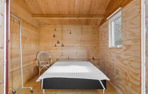 um quarto com uma cama e uma cadeira em 2 Bedroom Beautiful Home In Tisvildeleje em Tisvildeleje