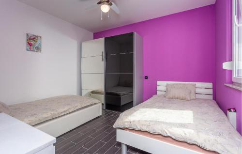 een slaapkamer met 2 bedden en een paarse muur bij Lovely Apartment In Hreljin With House Sea View in Hreljin