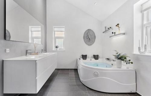 uma casa de banho branca com uma banheira e um lavatório em Gorgeous Home In Jerup With Sauna em Jerup