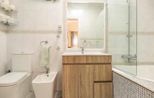 y baño con aseo, lavabo y bañera. en Gorgeous Home In Las Lagunas De Mijas With Kitchen, en Santa Fe de los Boliches