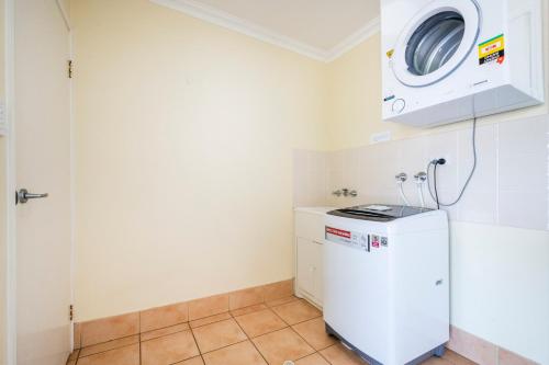 a laundry room with a washer and dryer at Oceania 11 - LJHooker Yamba in Yamba